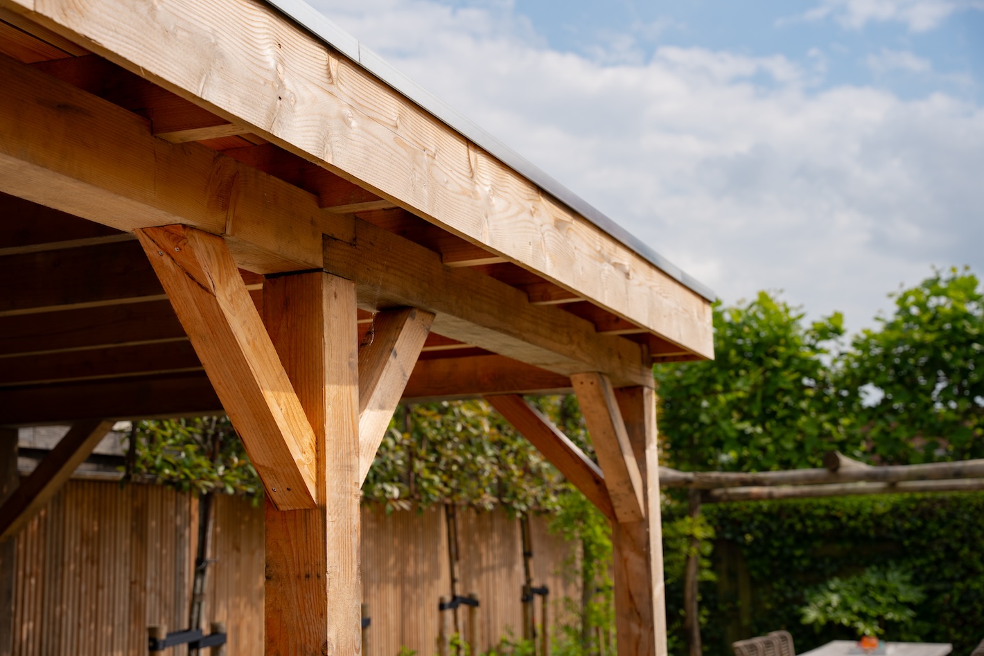 Detail van een houten overkapping, gebouwd tijdens een tuinrenovatie door Snijers Tuinen.