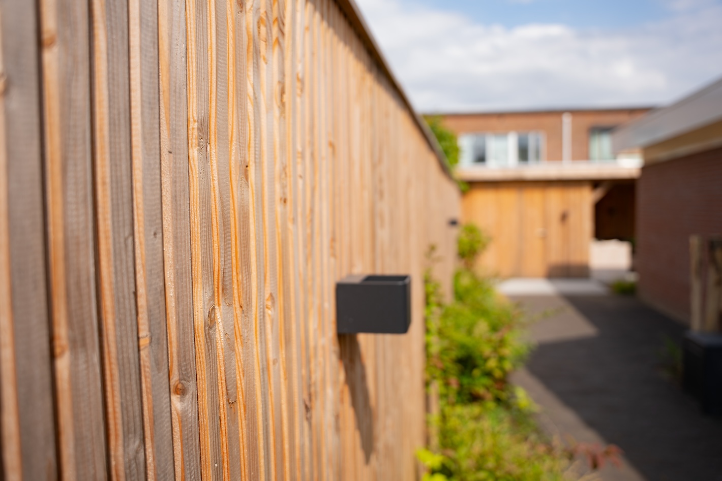 Nieuwe houten schutting met tuinverlichting, geplaatst door Snijers Tuinen tijdens een tuinrenovatie in Zeewolde.