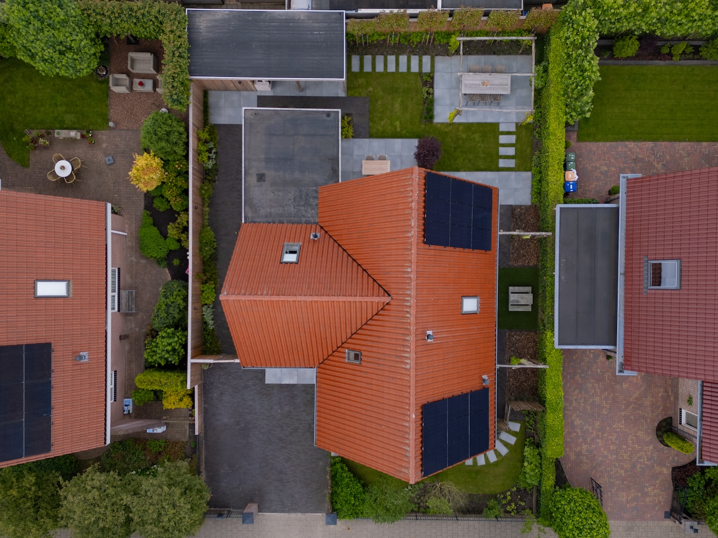 Luchtfoto van een compleet gerenoveerde tuin in Zeewolde door hovenier Snijers Tuinen, inclusief bestraatte oprit, terrassen, en gazon.