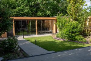 Symmetrische tuinindeling met moderne tegels en geometrisch plantenontwerp – Snijers Tuinen in Almere